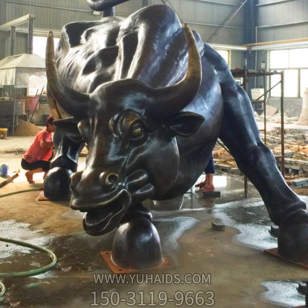 公園里擺放的一只黑色的玻璃鋼創(chuàng )意華爾街牛雕塑