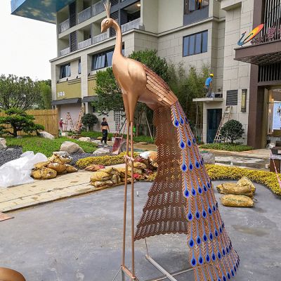 公園里一只拖著(zhù)尾巴的不銹鋼鏤空孔雀雕塑