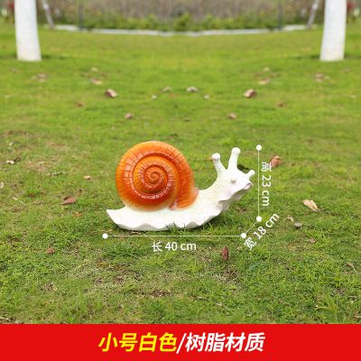 草地上擺放的白色爬行的樹(shù)脂創(chuàng  )意蝸牛雕塑
