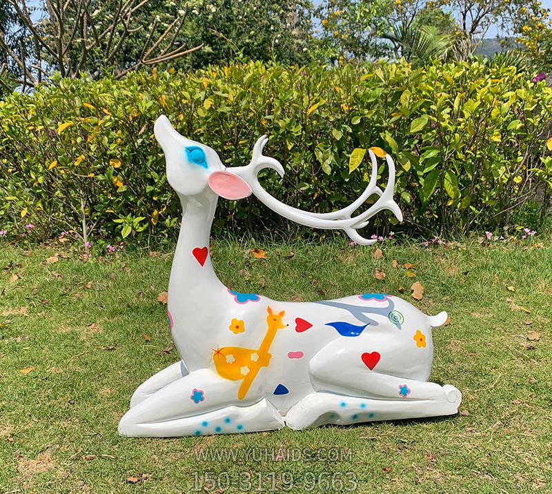 草坪上臥著(zhù)的玻璃鋼彩色公鹿梅花鹿雕塑