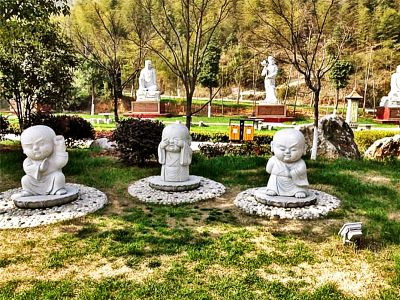 園林景區漢白玉姿態(tài)各異的和尚雕塑