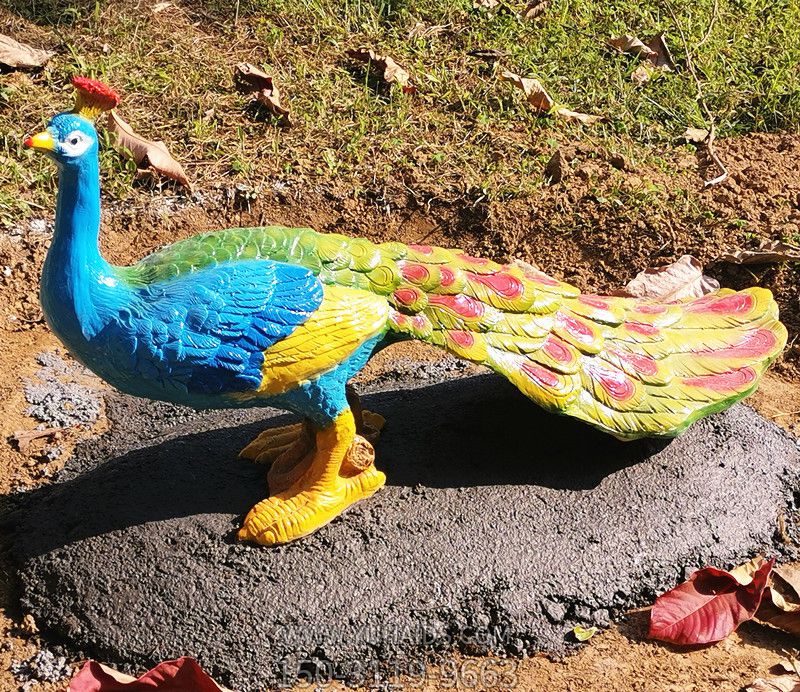 公園里一只拖著(zhù)尾巴散步的玻璃鋼彩繪孔雀雕塑