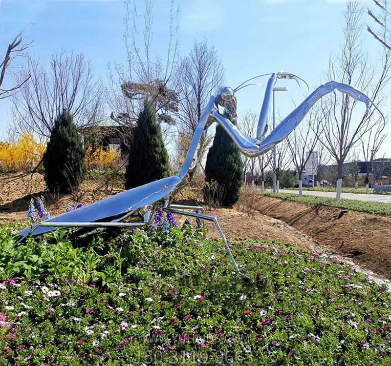 公園花叢里擺放的銀色的玻璃鋼創(chuàng )意螳螂雕塑