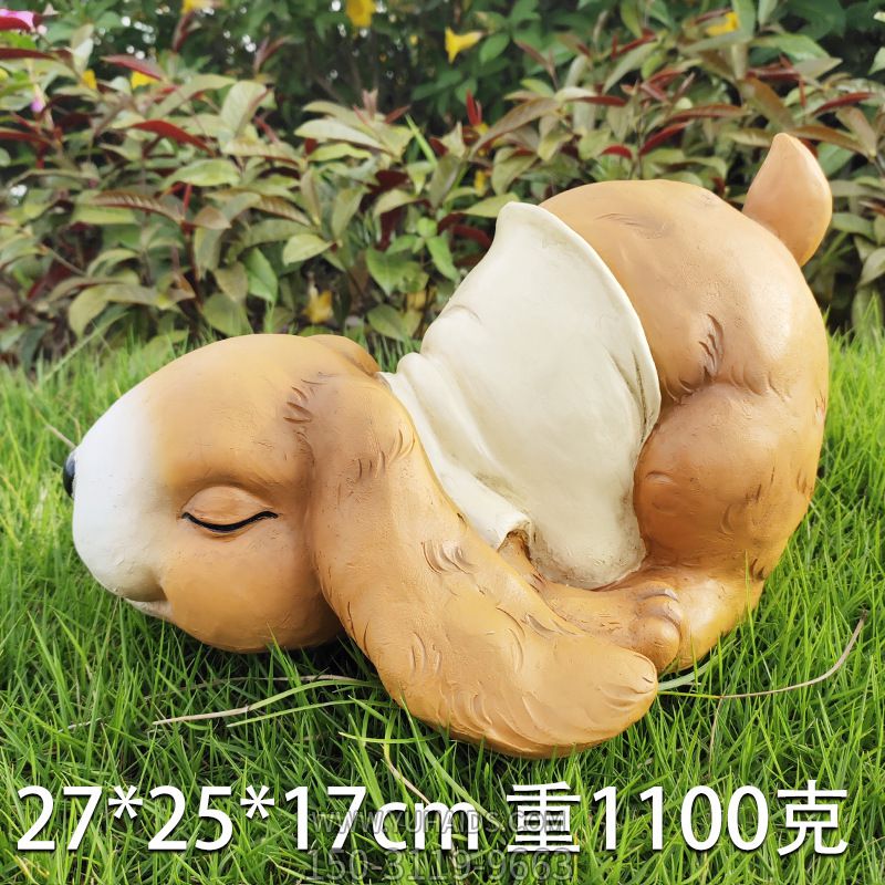 草坪中一只趴著(zhù)睡覺(jué)的玻璃鋼兔子雕塑