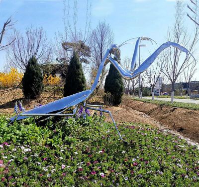 公園花叢里擺放的銀色的玻璃鋼創(chuàng  )意螳螂雕塑