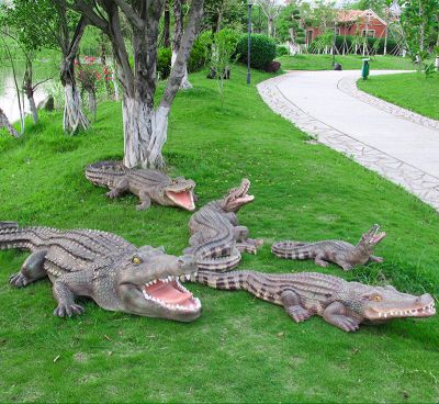 公園草地上擺放的一群張著(zhù)嘴巴的玻璃鋼仿真鱷魚(yú)雕塑