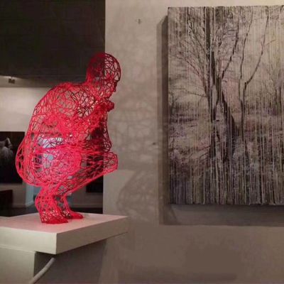 展覽館擺放不銹鋼蹲著(zhù)的鏤空人物雕塑擺件